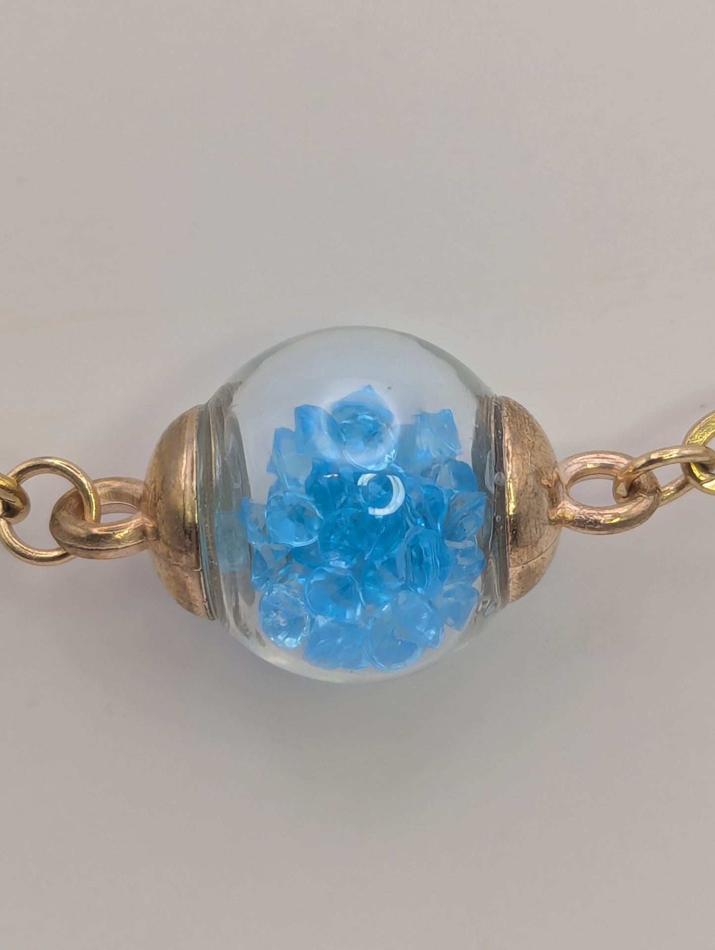 Aquamarine Rhinestone Globe on Gold Paperclip Bracelet With Dolphin Accent